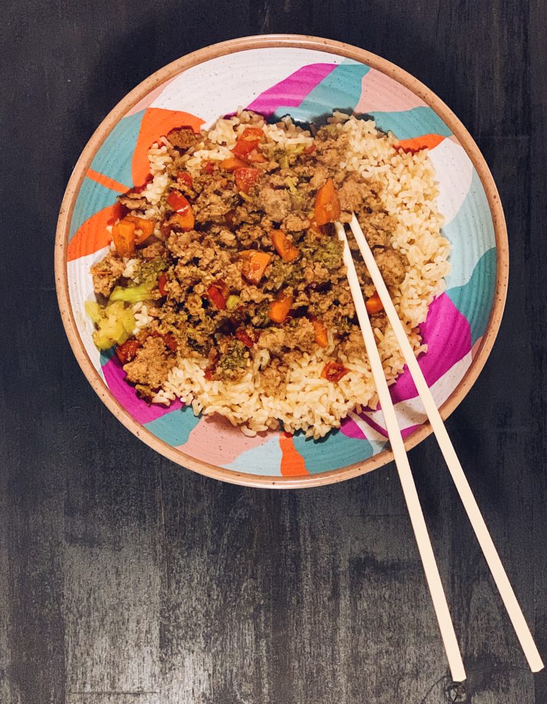 Teriyaki Rice Bowl with carrots, red bell peppers and broccoli served in a bowl with chopsticks.