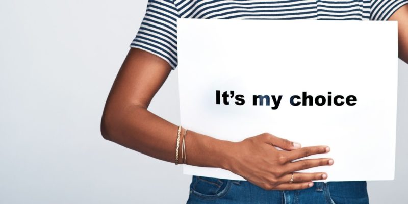 woman holding a sign across her body that says It's my choice