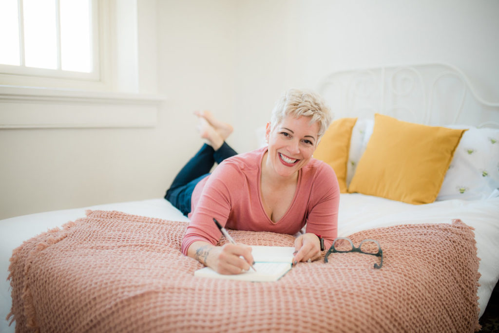gretchen schock laying on a bed and journaling