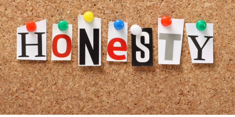 The word HONESTY spelled out on a corkboard with pushpins in each letter