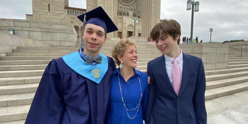 Gretchen Schock standing with her 2 kids, one in graduating from high school